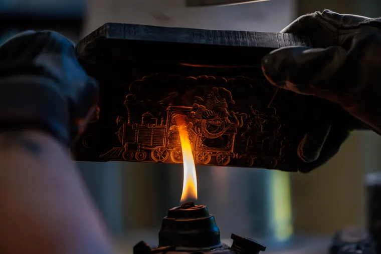 Eine Gussform wird über einer Flamme erhitzt